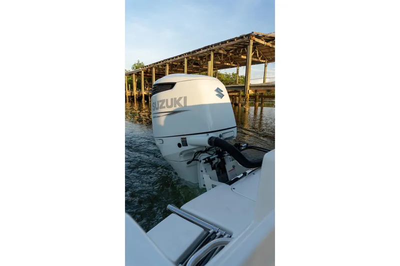 Slide: The Image of 2021 Sea Born LX24 Center Console with Suzuki outboard motor near wooden dock. - 11