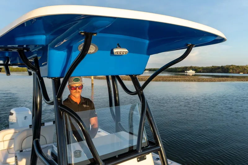 Slide: The Image of 2021 Sea Born LX24 Center Console boat on calm water, featuring a blue canopy. - 14