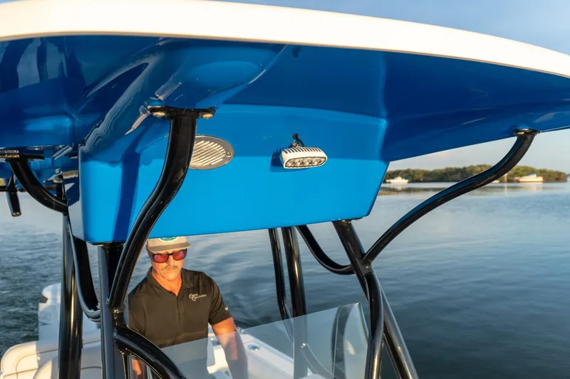 Slide: The Image of 2021 Sea Born LX24 Center Console boat on calm water, featuring blue canopy and modern design. - 15