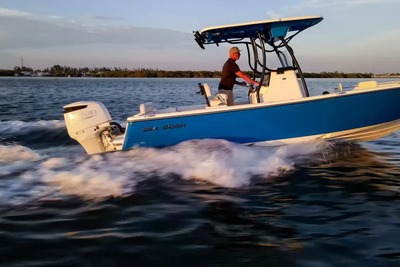 Slide: The Image of 2021 Sea Born LX24 Center Console boat cruising on water at sunset. - 37