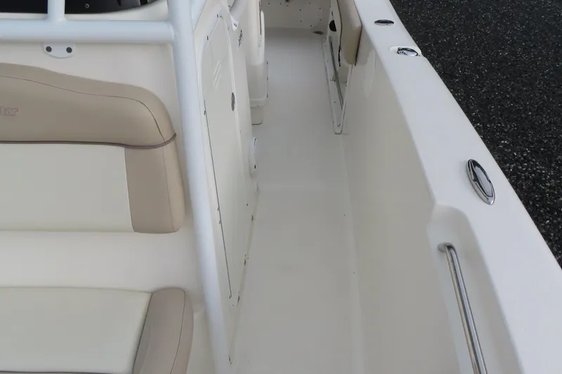 Slide: The Image of 2017 NauticStar 25 XS Offshore boat interior with beige seating and white deck. - 17