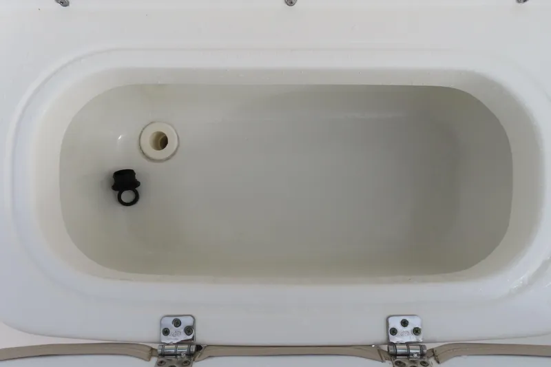 Slide: The Image of 2017 NauticStar 25 XS Offshore boat compartment, open with drain plug visible. - 19