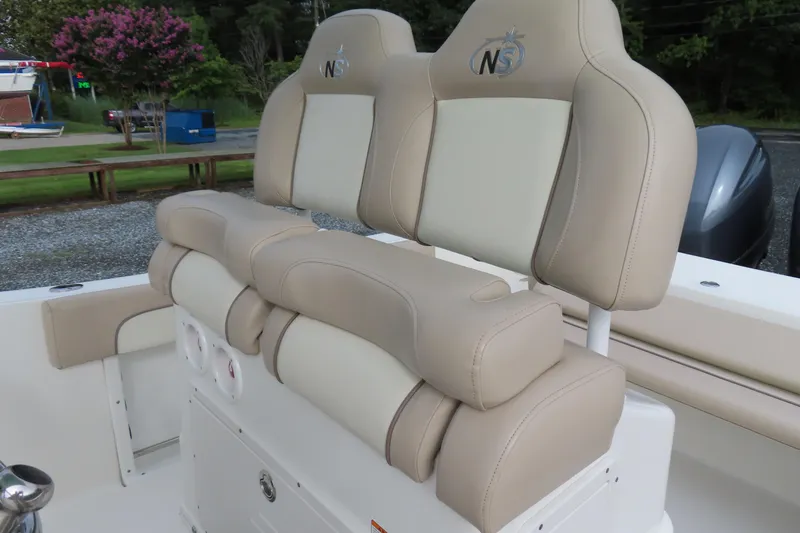 Slide: The Image of 2017 NauticStar 25 XS Offshore boat seats, beige and white upholstery, outdoor setting. - 23