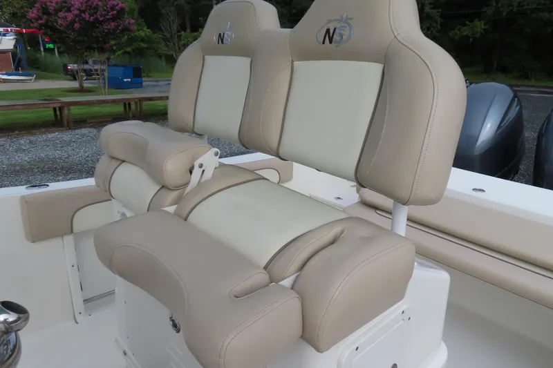 Slide: The Image of 2017 NauticStar 25 XS Offshore boat seating with beige upholstery and logo. - 24