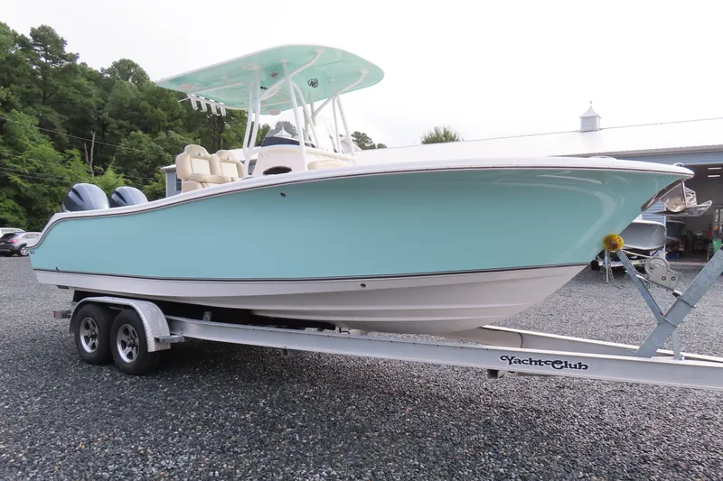Slide: The Image of 2017 NauticStar 25 XS Offshore boat on trailer, light blue hull, parked outdoors. - 3