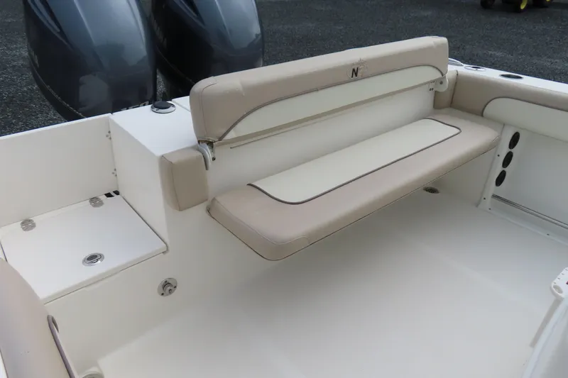 Slide: The Image of 2017 NauticStar 25 XS Offshore boat interior with beige seating and dual engines. - 32