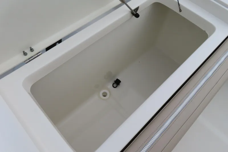 Slide: The Image of 2017 NauticStar 25 XS Offshore boat storage compartment, open lid, white interior. - 37