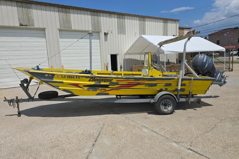 The Image of Yellow Rookie 22 boat from 2006 on trailer, parked outside a garage. - 0