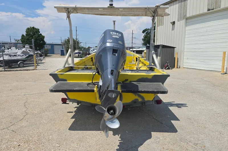Slide: The Image of Yellow Rookie 22 boat with outboard motor, parked outdoors, 2006 model. - 6