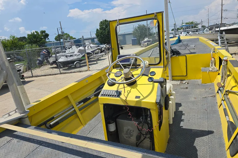 Slide: The Image of Yellow Rookie 22 boat from 2006 with steering wheel, docked near other boats. - 8