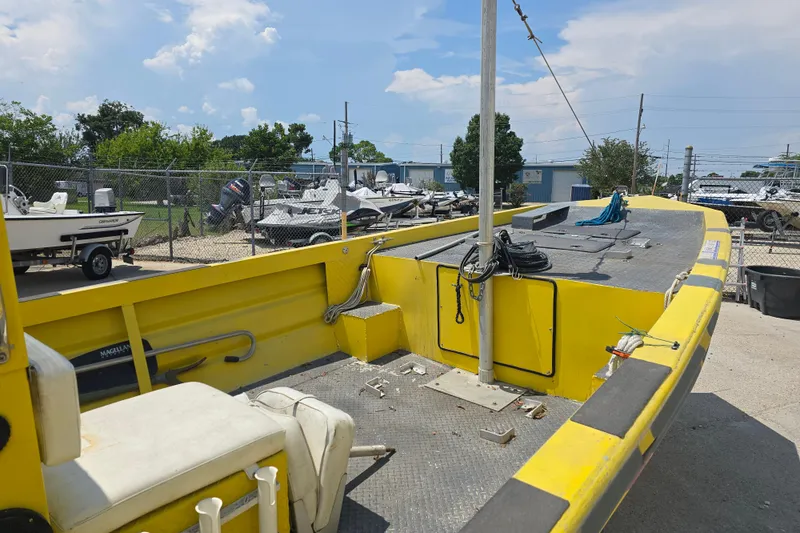 Slide: The Image of Yellow Rookie 22 boat from 2006 in a boatyard, surrounded by other vessels. - 9