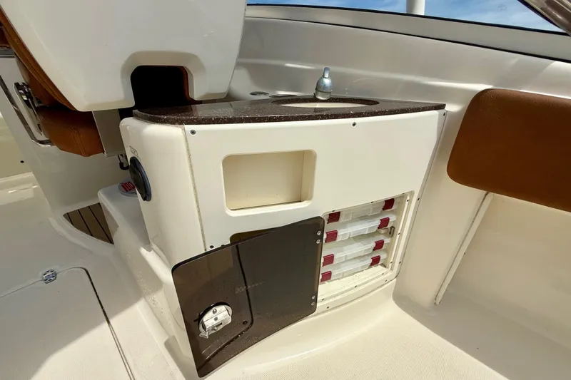 Slide: The Image of 2015 Scout 245 Dorado boat interior with storage compartments and sink. - 12