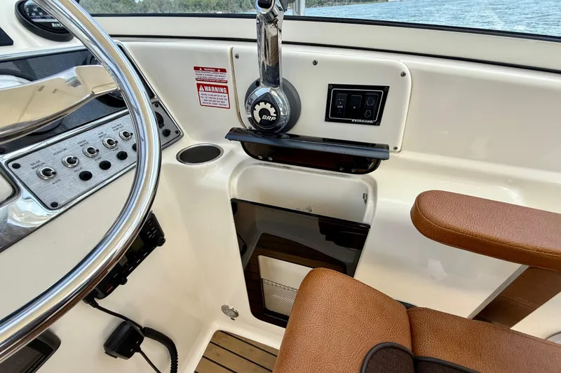 Slide: The Image of 2015 Scout 245 Dorado boat helm with controls and brown seating. - 18