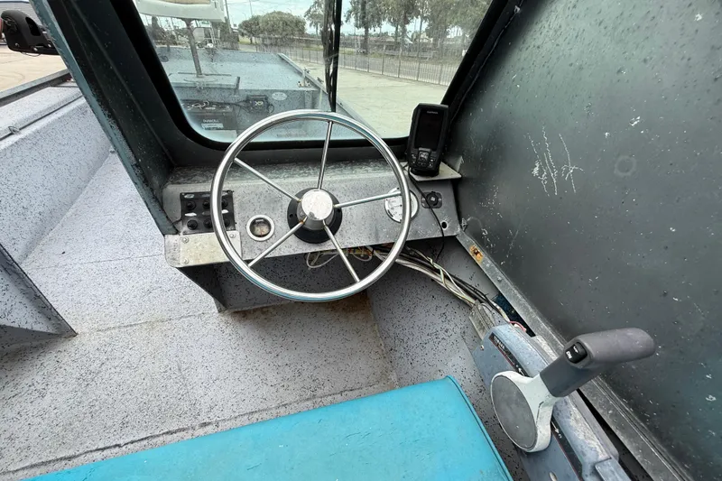 Slide: The Image of Interior of a 1983 Scully's 16 WT boat showing steering wheel and controls. - 10