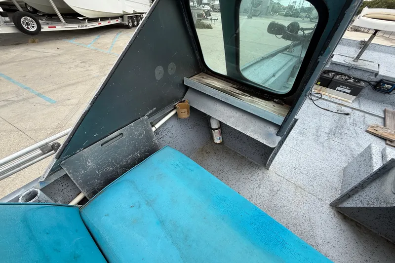 Slide: The Image of Interior of a 1983 Scully's 16 WT boat with blue seating and window view. - 11