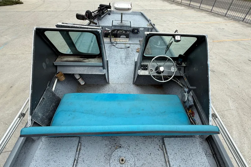 Slide: The Image of 1983 Scully's 16 WT boat interior with blue seating and steering wheel. - 6