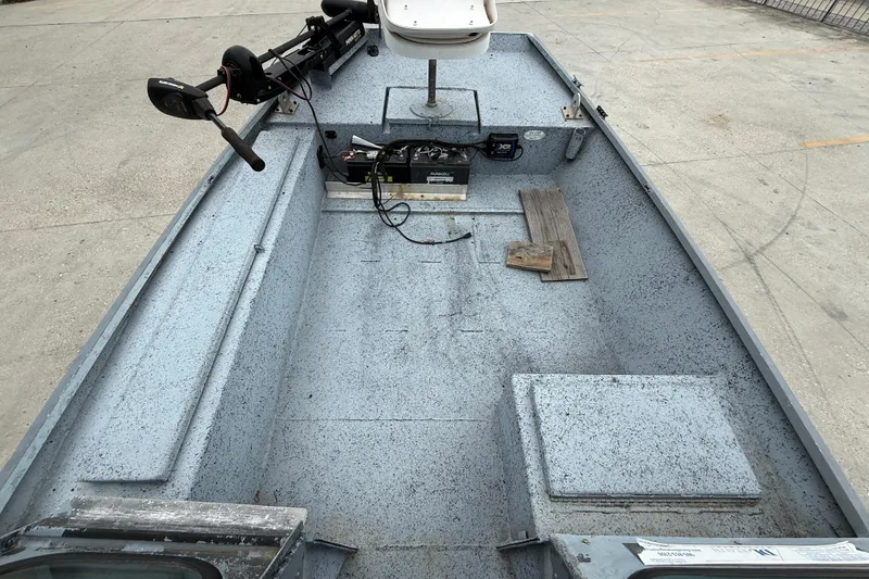 Slide: The Image of 1983 Scully's 16 WT boat interior with motor and equipment on concrete surface. - 7