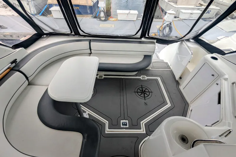 Slide: The Image of 2000 Cruisers Yachts 3870 Express interior with seating, table, and compass design flooring. - 11