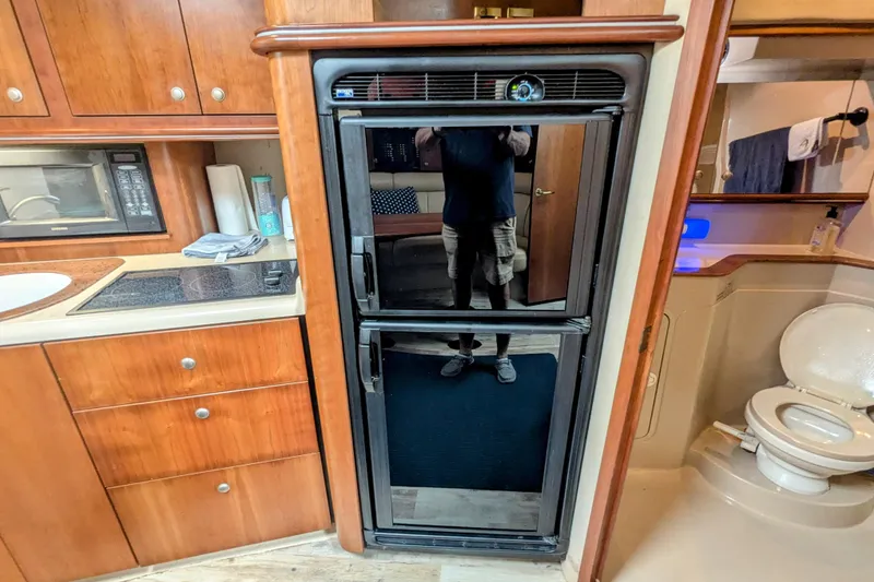 Slide: The Image of 2000 Cruisers Yachts 3870 Express interior with kitchen and bathroom amenities. - 22