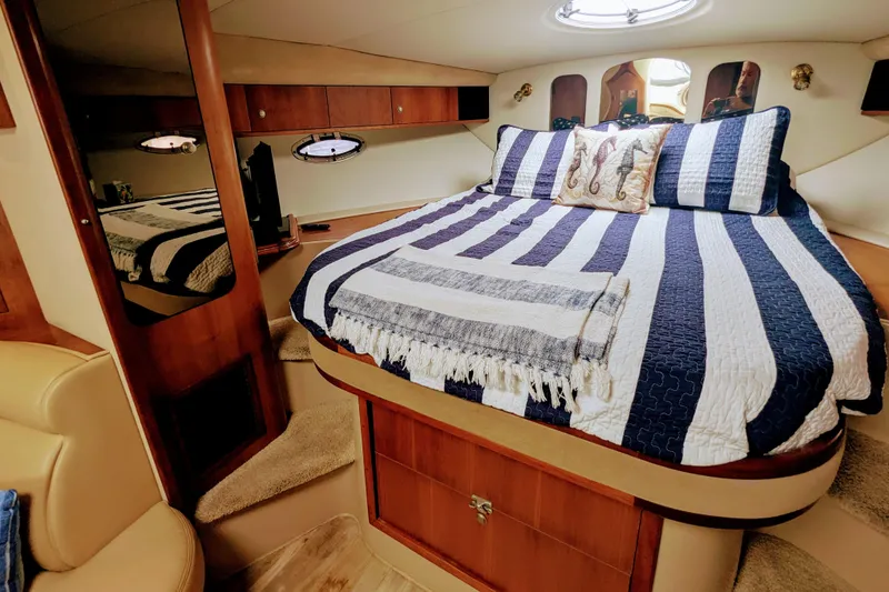 Slide: The Image of Luxurious cabin interior of 2000 Cruisers Yachts 3870 Express with striped bedding. - 24