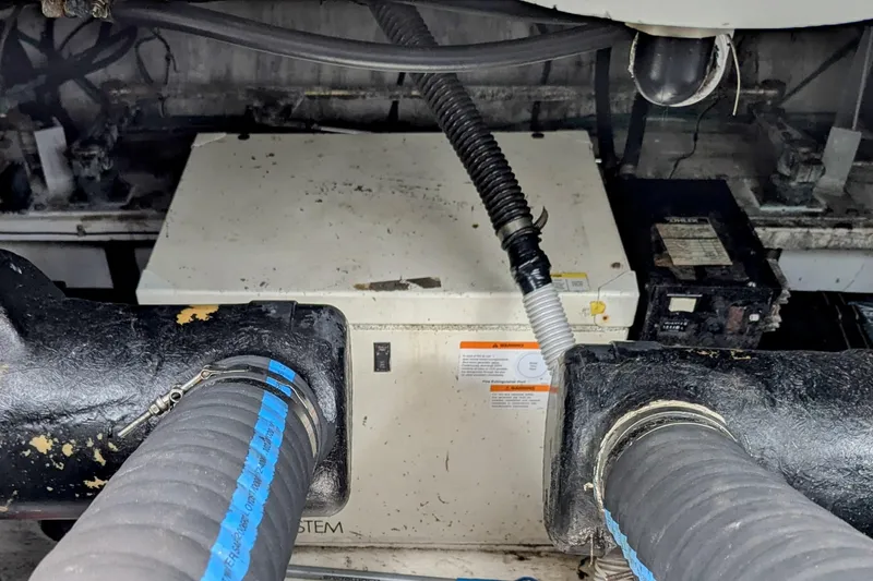 Slide: The Image of Engine compartment of 2000 Cruisers Yachts 3870 Express with visible hoses and components. - 37