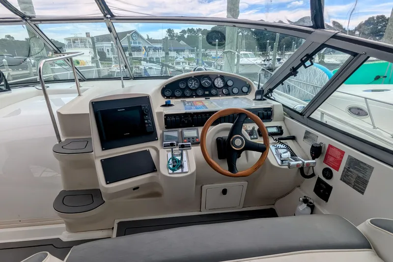 Slide: The Image of Cockpit of 2000 Cruisers Yachts 3870 Express with steering wheel and navigation controls. - 8