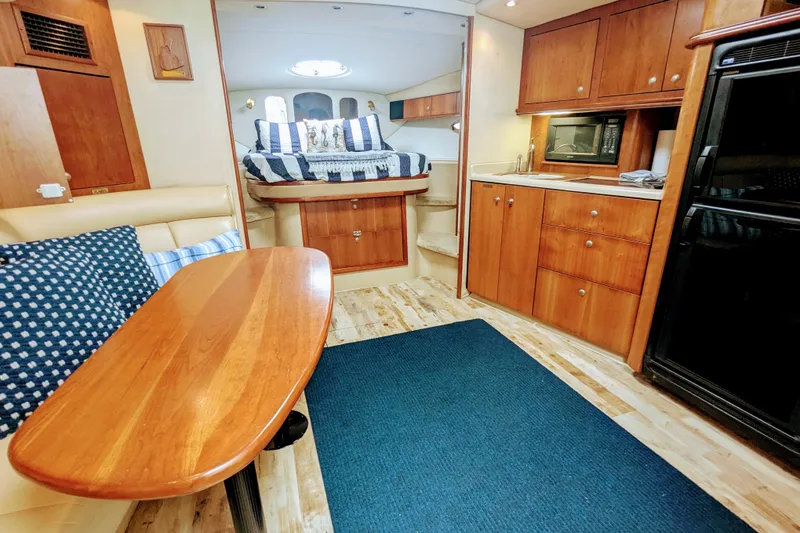 Slide: The Image of Interior of 2000 Cruisers Yachts 3870 Express, featuring cozy dining and sleeping areas. - 18