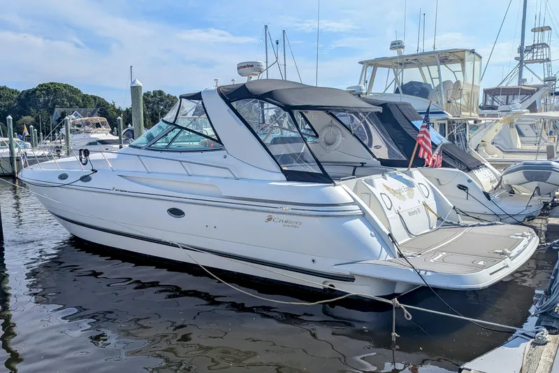 Slide: The Image of 2000 Cruisers Yachts 3870 Express docked at marina, featuring sleek design and American flag. - 2