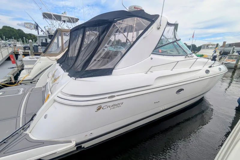 Slide: The Image of 2000 Cruisers Yachts 3870 Express docked at marina, featuring sleek design and canopy. - 3