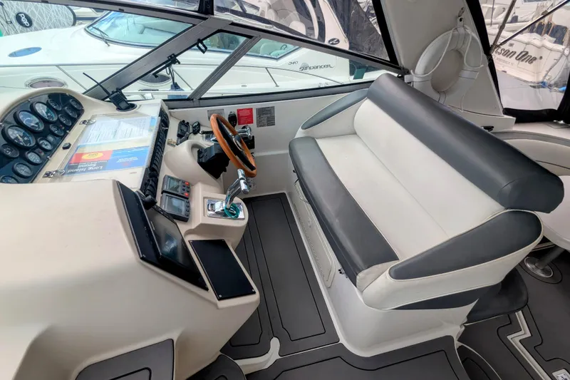 Slide: The Image of 2000 Cruisers Yachts 3870 Express helm with steering wheel, controls, and seating. - 6