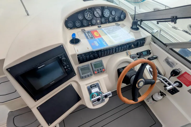 Slide: The Image of 2000 Cruisers Yachts 3870 Express helm with navigation equipment and wooden steering wheel. - 7