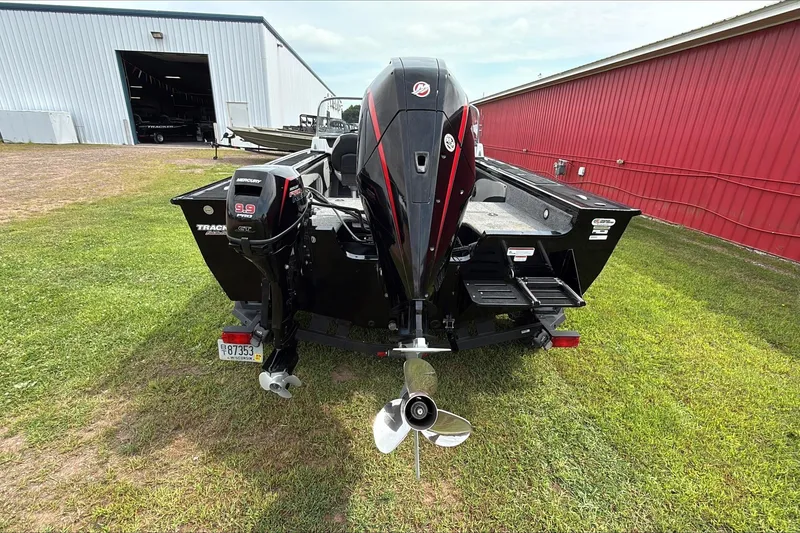 Slide: The Image of 2019 Tracker Targa V-19 WT Tournament Edition boat with Mercury outboard motor, parked on grass. - 2