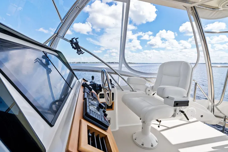 Slide: The Image of 2019 Sabre Flybridge helm with white captain's chair and ocean view. - 20