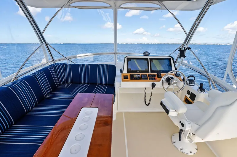 Slide: The Image of 2019 Sabre Flybridge yacht interior with blue seating, wooden table, and navigation controls. - 22