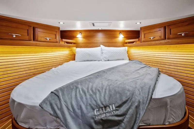 Slide: The Image of Luxurious 2019 Sabre Flybridge yacht cabin with cozy bed and elegant wood paneling. - 25