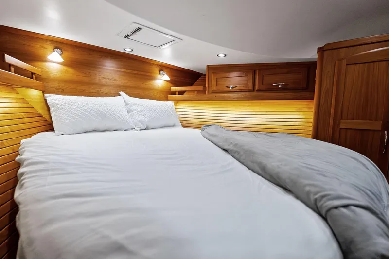 Slide: The Image of Luxurious 2019 Sabre Flybridge cabin interior with cozy bed and wooden accents. - 26