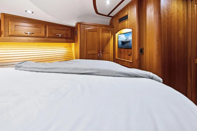 Slide: The Image of Luxurious 2019 Sabre Flybridge yacht cabin with wooden interior and cozy bedding. - 28