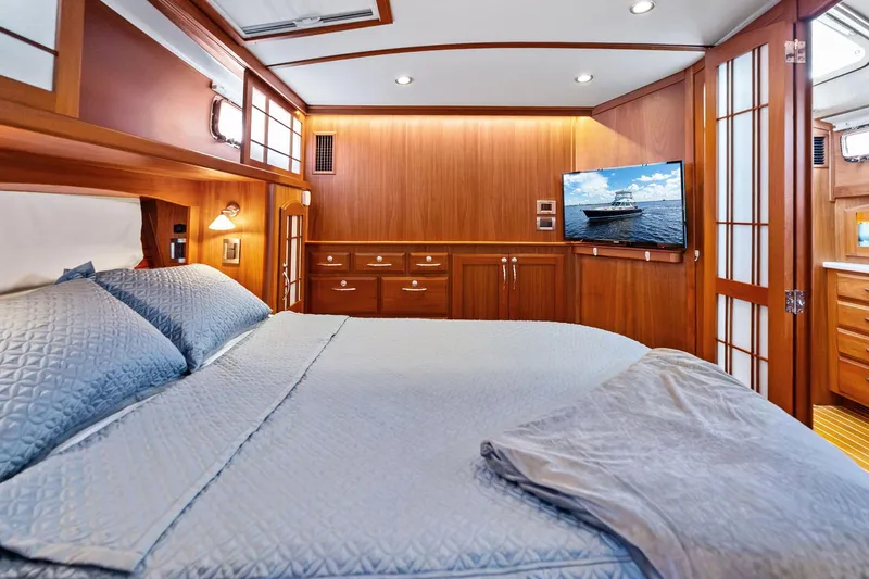 Slide: The Image of Luxurious 2019 Sabre Flybridge yacht bedroom with wood paneling and modern amenities. - 3
