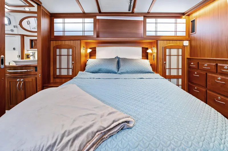 Slide: The Image of Luxurious 2019 Sabre Flybridge yacht bedroom with elegant wood finish and cozy bedding. - 38