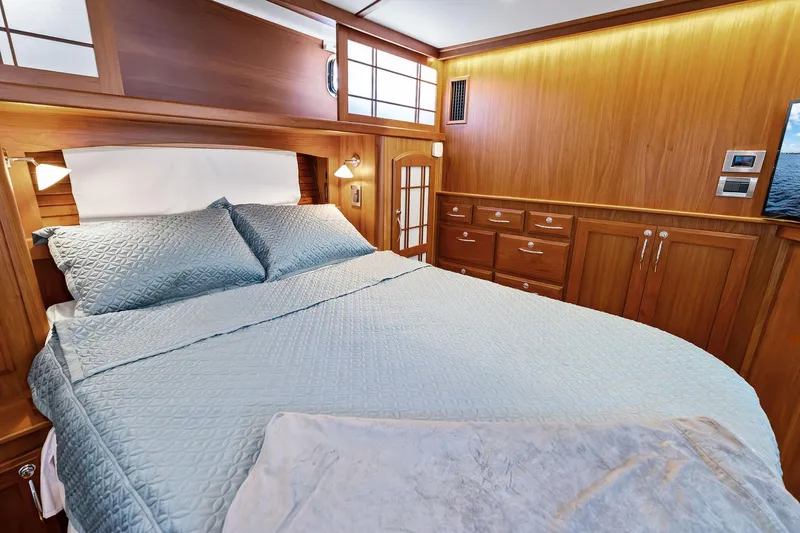 Slide: The Image of Luxurious 2019 Sabre Flybridge cabin with elegant wood paneling and cozy bedding. - 39