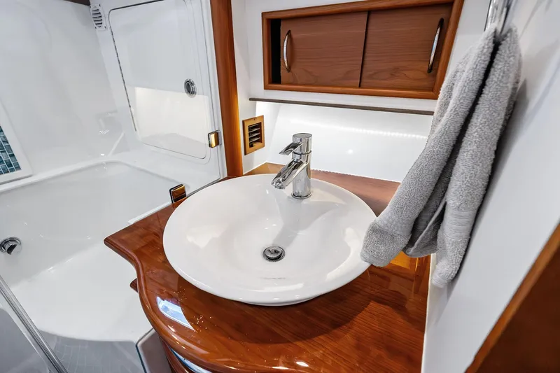 Slide: The Image of Luxurious 2019 Sabre Flybridge bathroom with elegant sink and wooden cabinetry. - 41