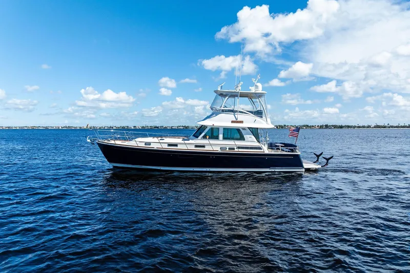 Slide: The Image of 2019 Sabre Flybridge yacht cruising on a sunny day with blue skies and calm waters. - 58