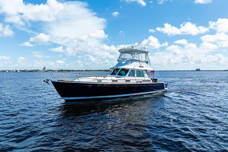 Slide: The Image of 2019 Sabre Flybridge yacht cruising on open water under a clear blue sky. - 60