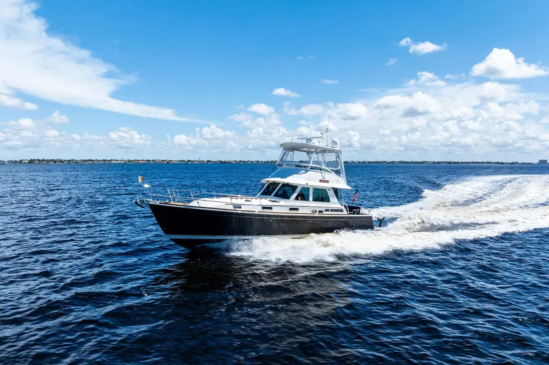 Slide: The Image of 2019 Sabre Flybridge cruising on open water under a clear blue sky. - 61