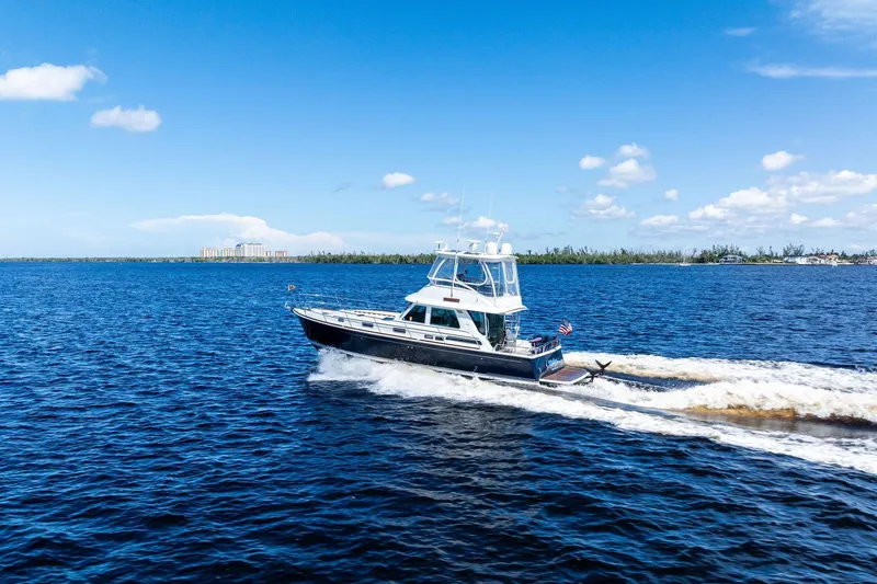 Slide: The Image of 2019 Sabre Flybridge yacht cruising on open blue water under a clear sky. - 63