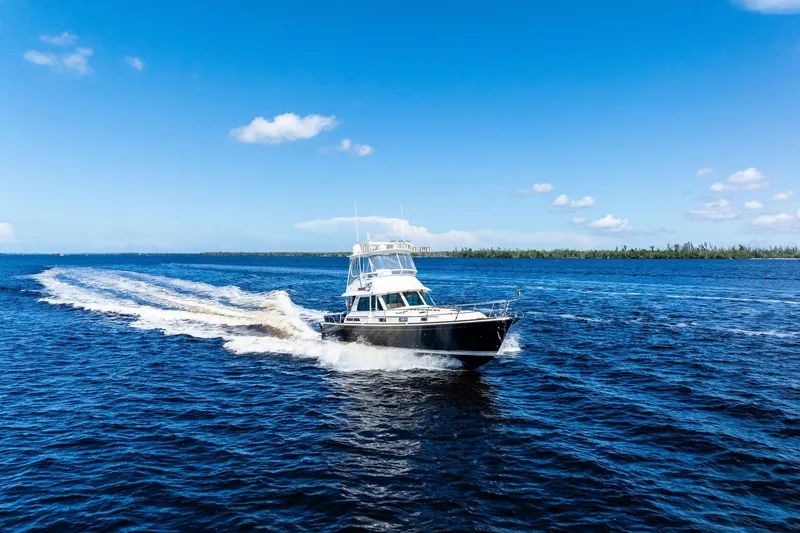 Slide: The Image of 2019 Sabre Flybridge cruising on open blue water under clear skies. - 64