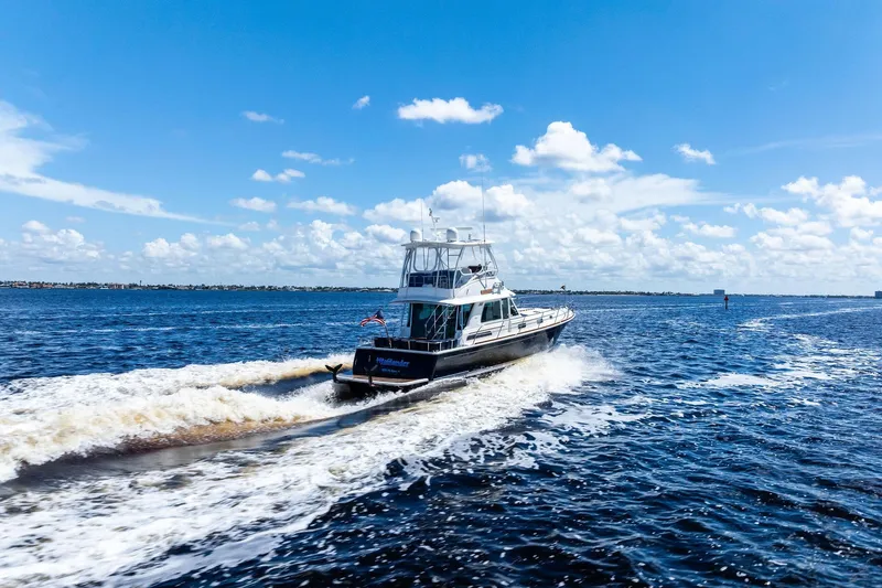 Slide: The Image of 2019 Sabre Flybridge cruising on open water under a clear blue sky. - 65