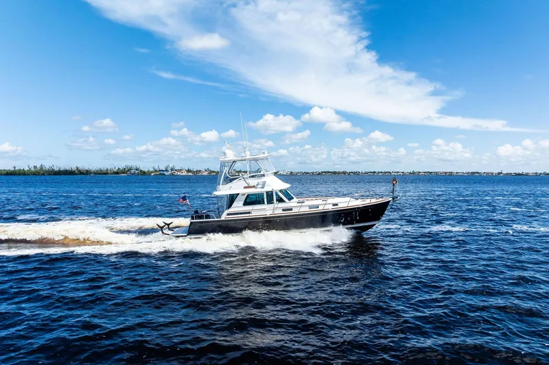 Slide: The Image of 2019 Sabre Flybridge cruising on open water under a clear blue sky. - 66