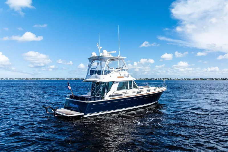 Slide: The Image of 2019 Sabre Flybridge yacht cruising on open water under a clear blue sky. - 67