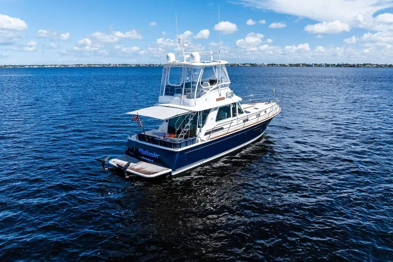 Slide: The Image of 2019 Sabre Flybridge yacht cruising on open water under a clear blue sky. - 68